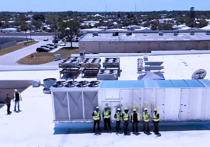 Workers on a roof installing commercial refrigeration units.